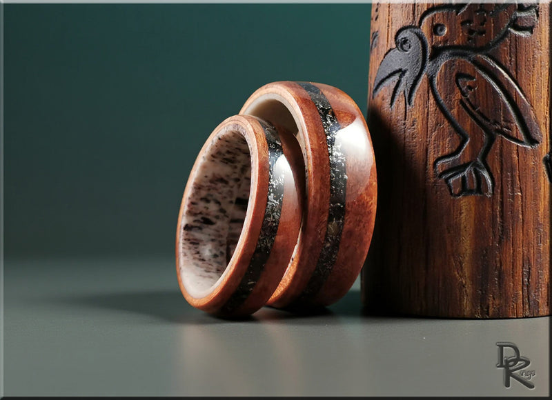 Elegant ring sets made of wood and metal with unique textured design displayed beside a carved wooden object