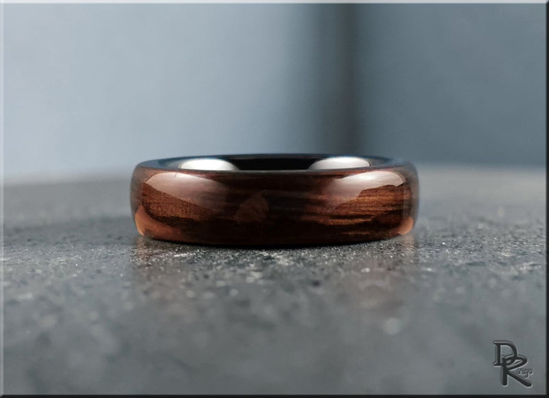 Bentwood rings featuring layered wood veneer with green stone inlay on a polished surface