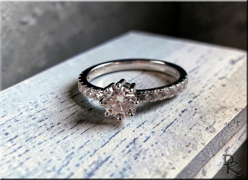 Elegant moissanite collection silver ring with a large round center stone and smaller stones on band