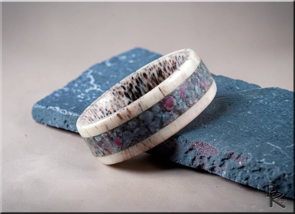 Antler ring with kyanite and ruby inlay by DR Rings displayed on textured blue stone
