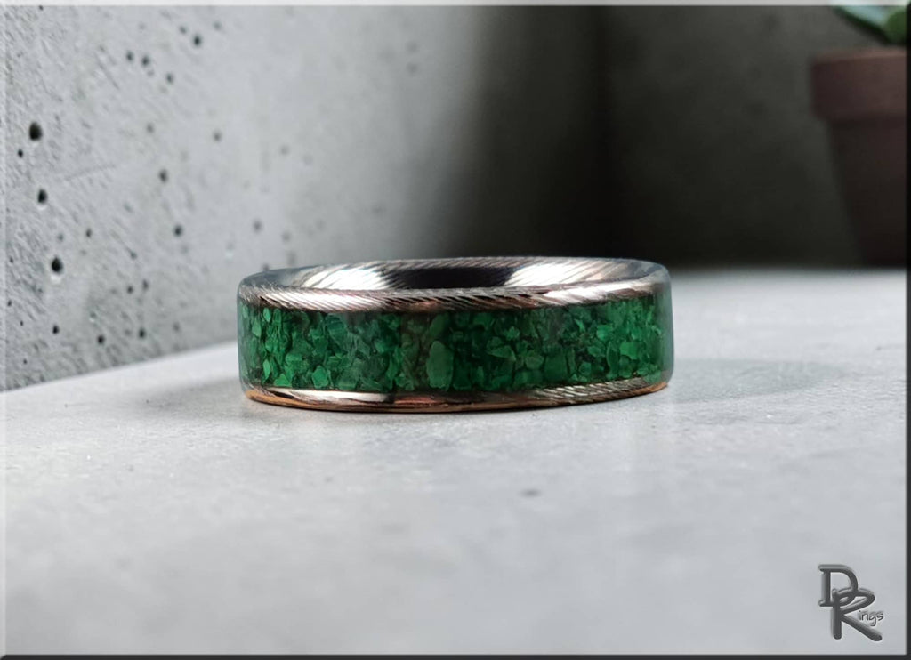 Damascus steel ring with malachite featuring a green stone inlay and textured metal edges