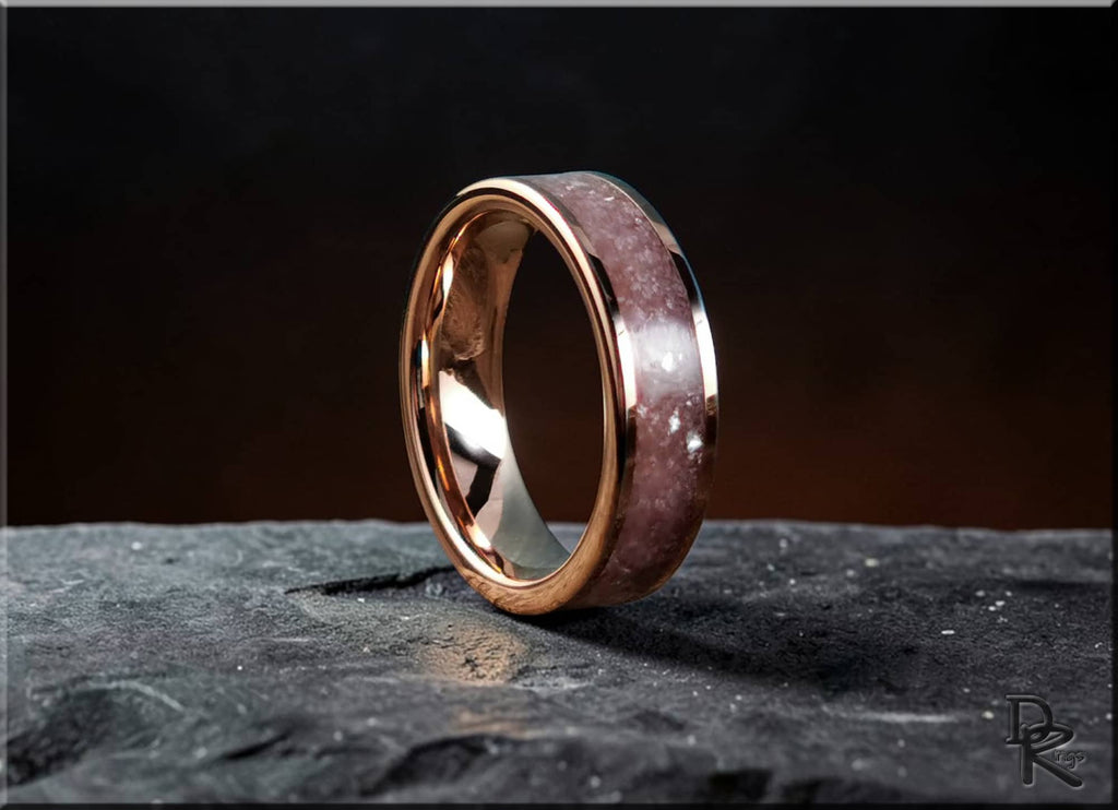 Rose tungsten ring with lepidolite stone inlay displayed on a textured dark surface