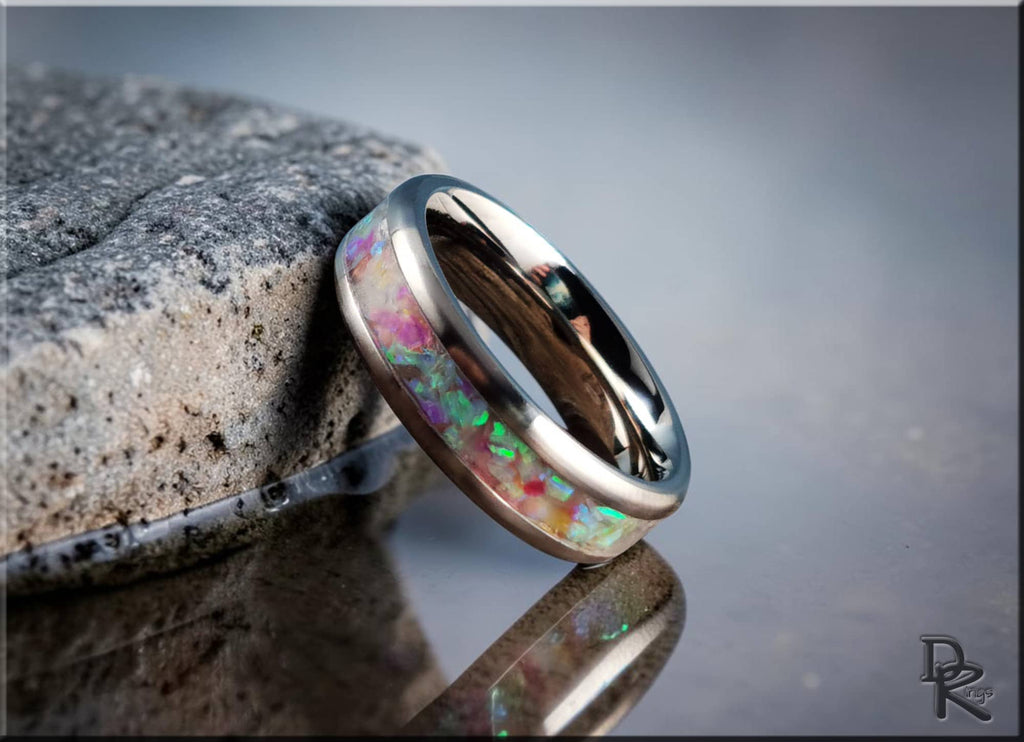 DR Rings titanium ring with inlay featuring colorful opal design on a reflective surface