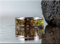 DR Rings titanium ring with inlay featuring green and brown opal design on reflective surface