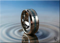 DR Rings tungsten as a ring with blue crushed stone inlay on reflective water surface