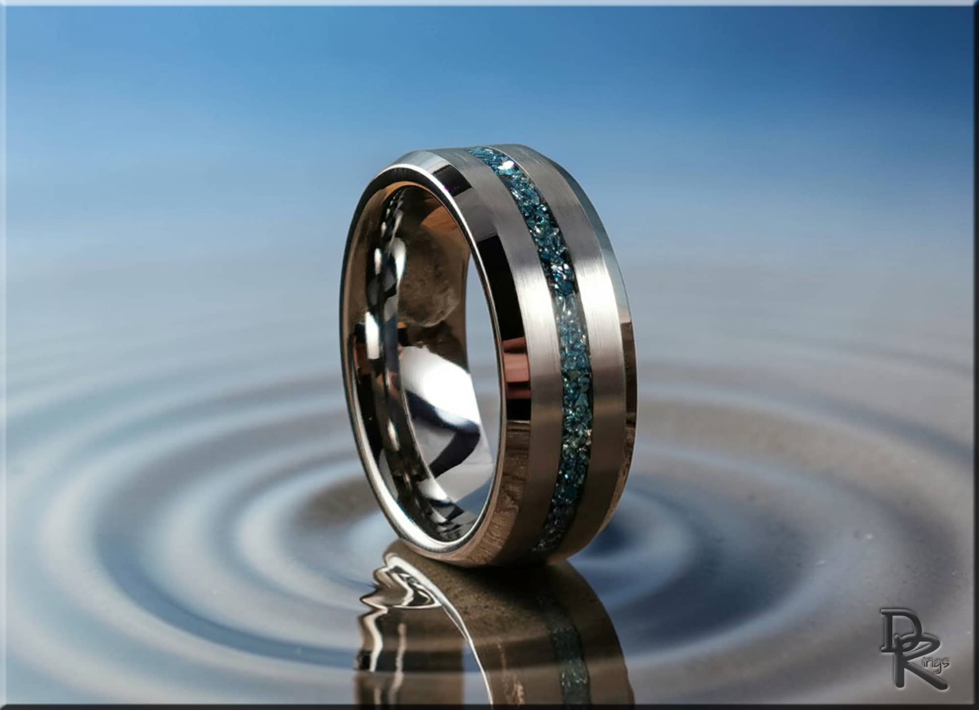 DR Rings tungsten as a ring with blue crushed stone inlay on reflective water surface