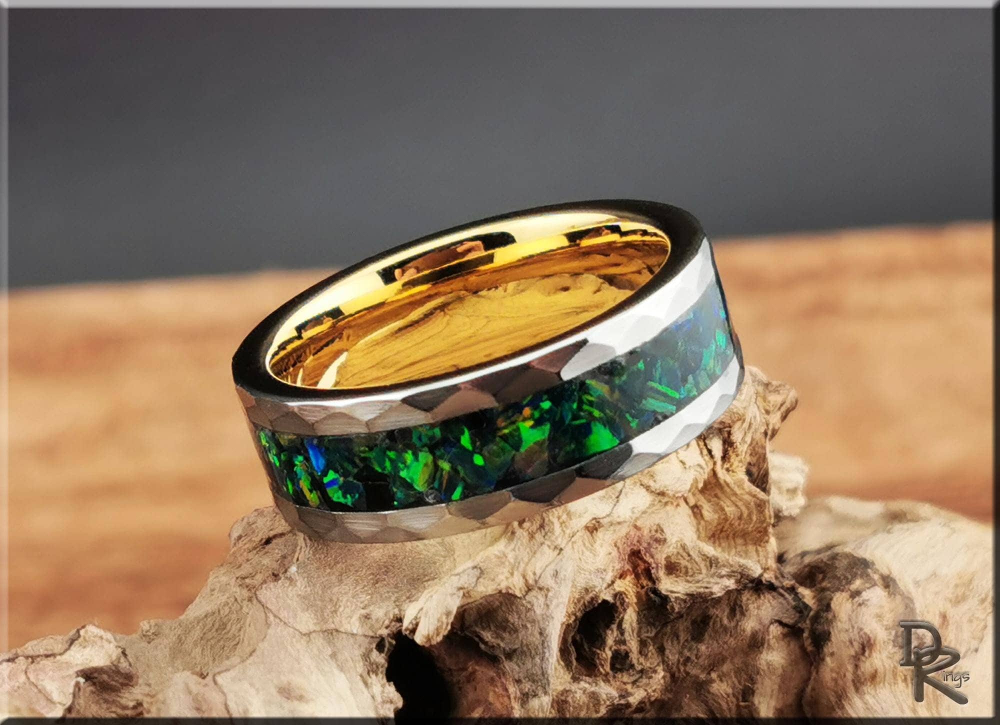 DR Rings tungsten ring with green opal inlay and gold interior band on natural wood background