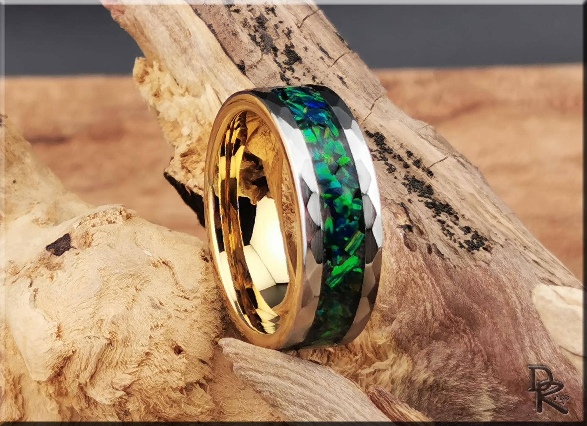 DR Rings tungsten ring with green opal channel and gold interior on rustic wood background