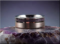 DR Rings tungsten ring with amethyst band resting on a purple agate stone