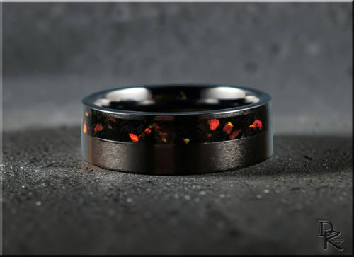 DR Rings black band ring opal inlay with vibrant red and orange flecks on dark textured surface