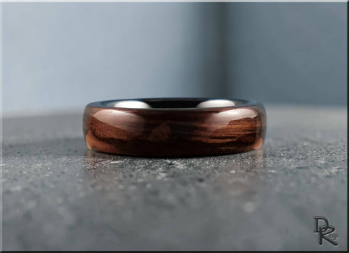 Bog oak ring on ceramic surface showcasing polished wood grain and smooth finish by DR Rings