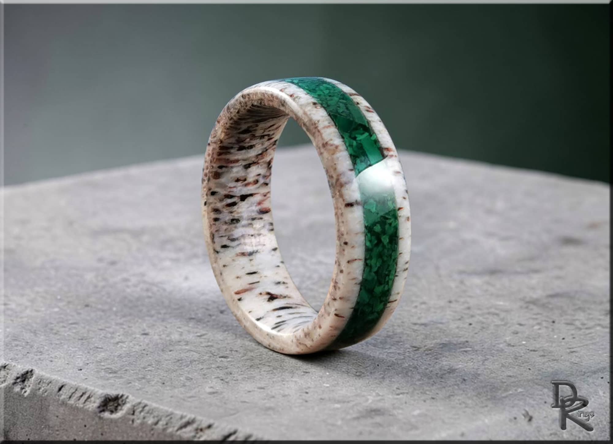 DR Rings handcrafted antler ring with green inlay on textured stone surface