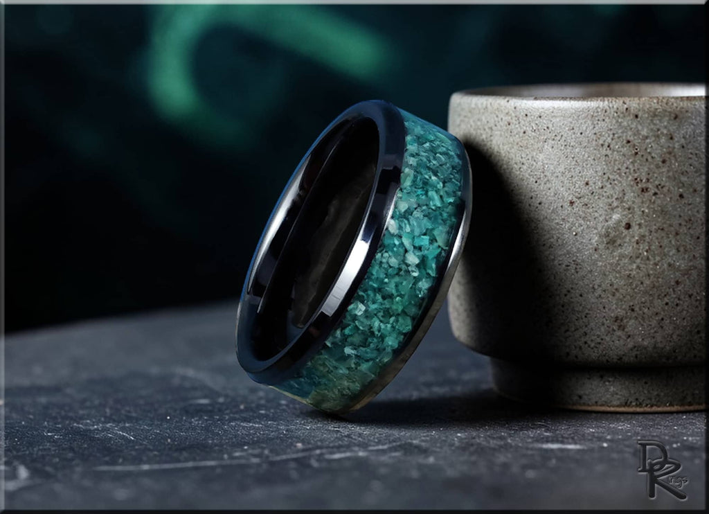 Ceramic ring with inlay featuring a blue-green textured inlay next to a ceramic cup