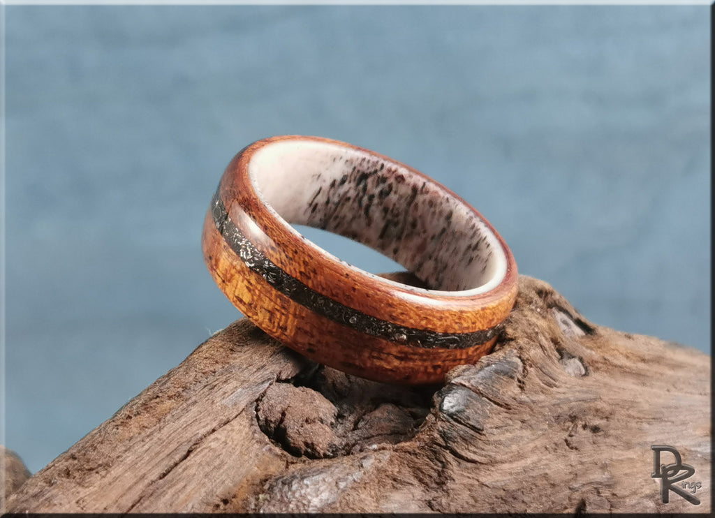 Wood ring with meteorite inlay on deer antler core displayed on rustic wooden surface by DR Rings