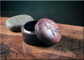 DR Rings open walnut ring box with engraved logo on wooden surface and stone in background