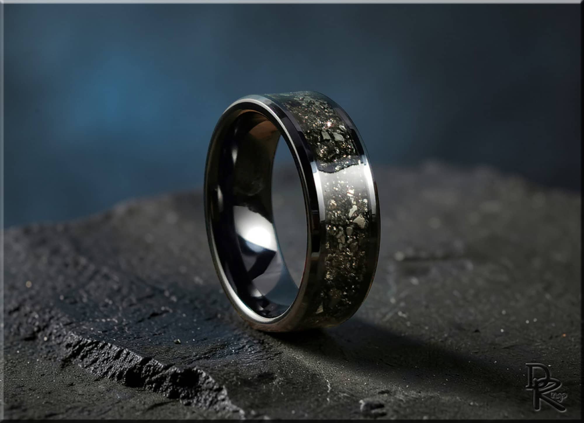 DR Rings ceramic ring with pyrite inlay on dark textured surface with reflective black finish
