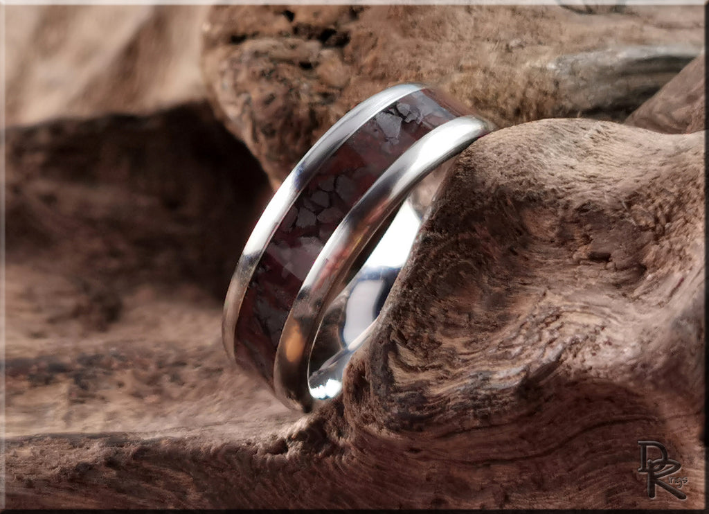 DR Rings titanium smart ring with dark inlay resting on rustic wood surface