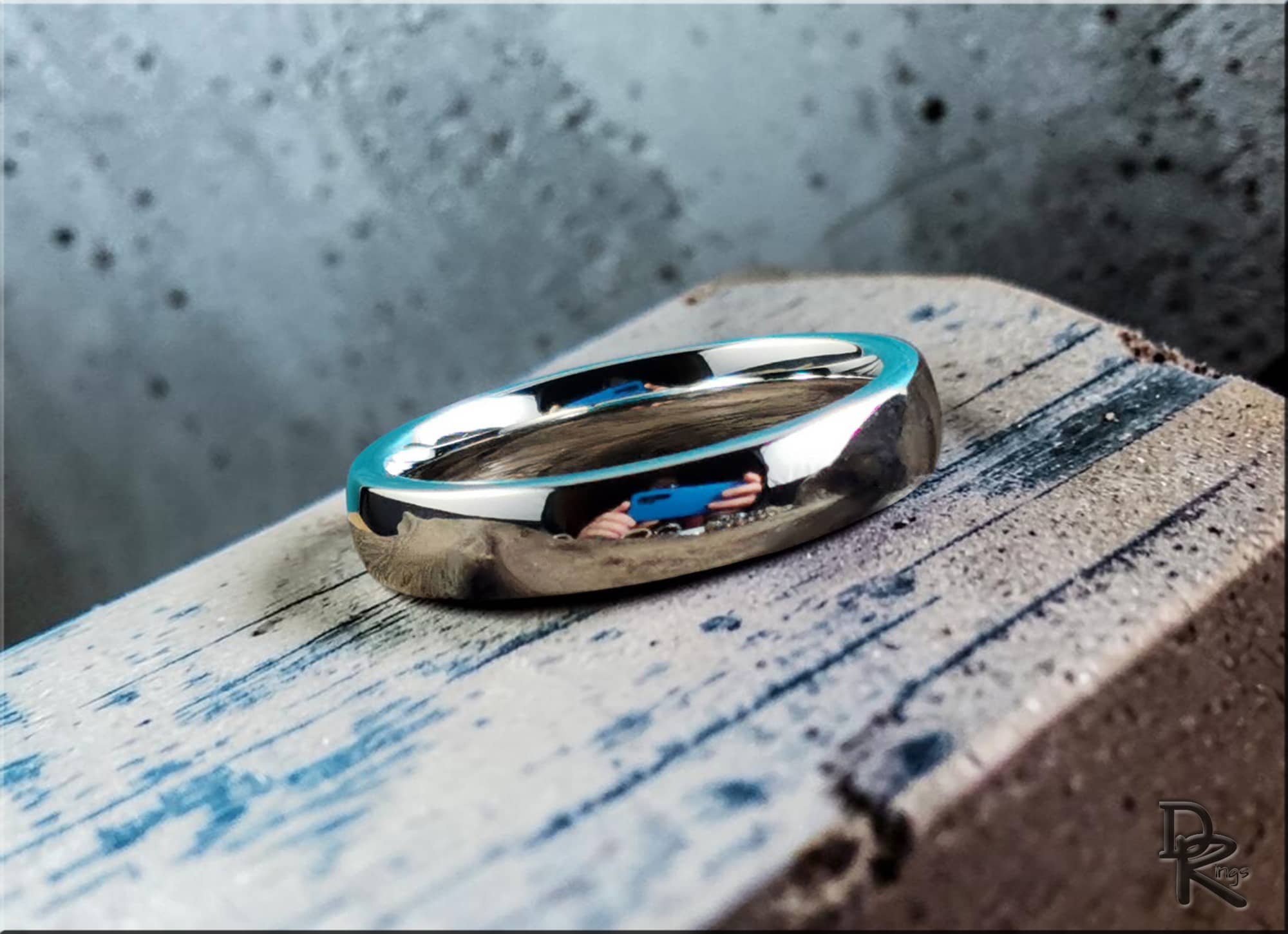Domed cobalt ring by DR Rings with polished reflective surface on a rustic wooden block