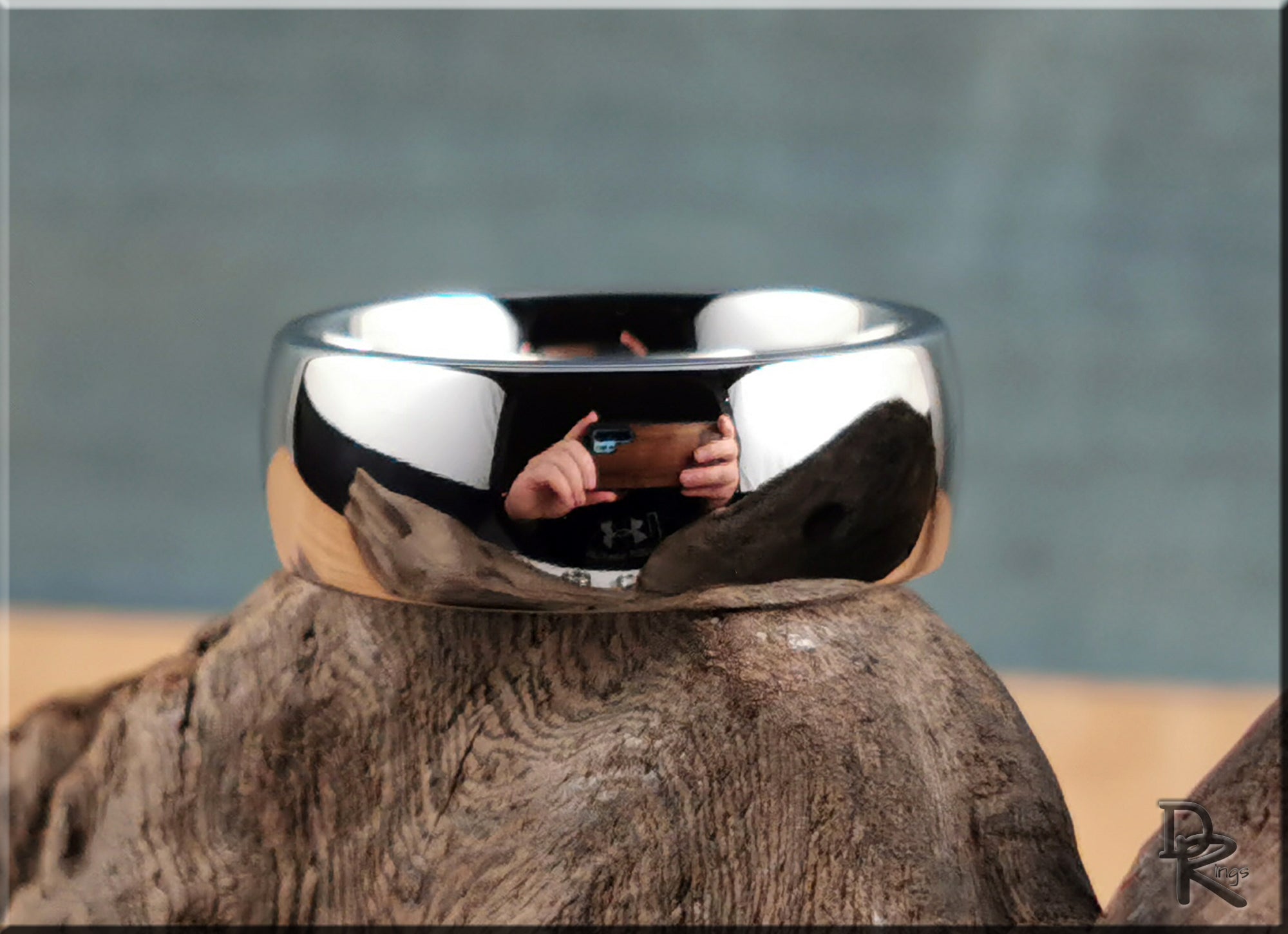 DR Rings polished domed cobalt ring with a shiny reflective surface on rustic wood background