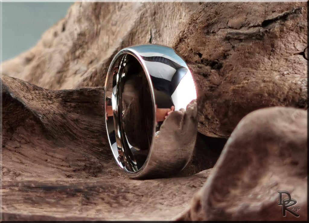 Shiny domed cobalt ring from DR Rings resting on textured wood background