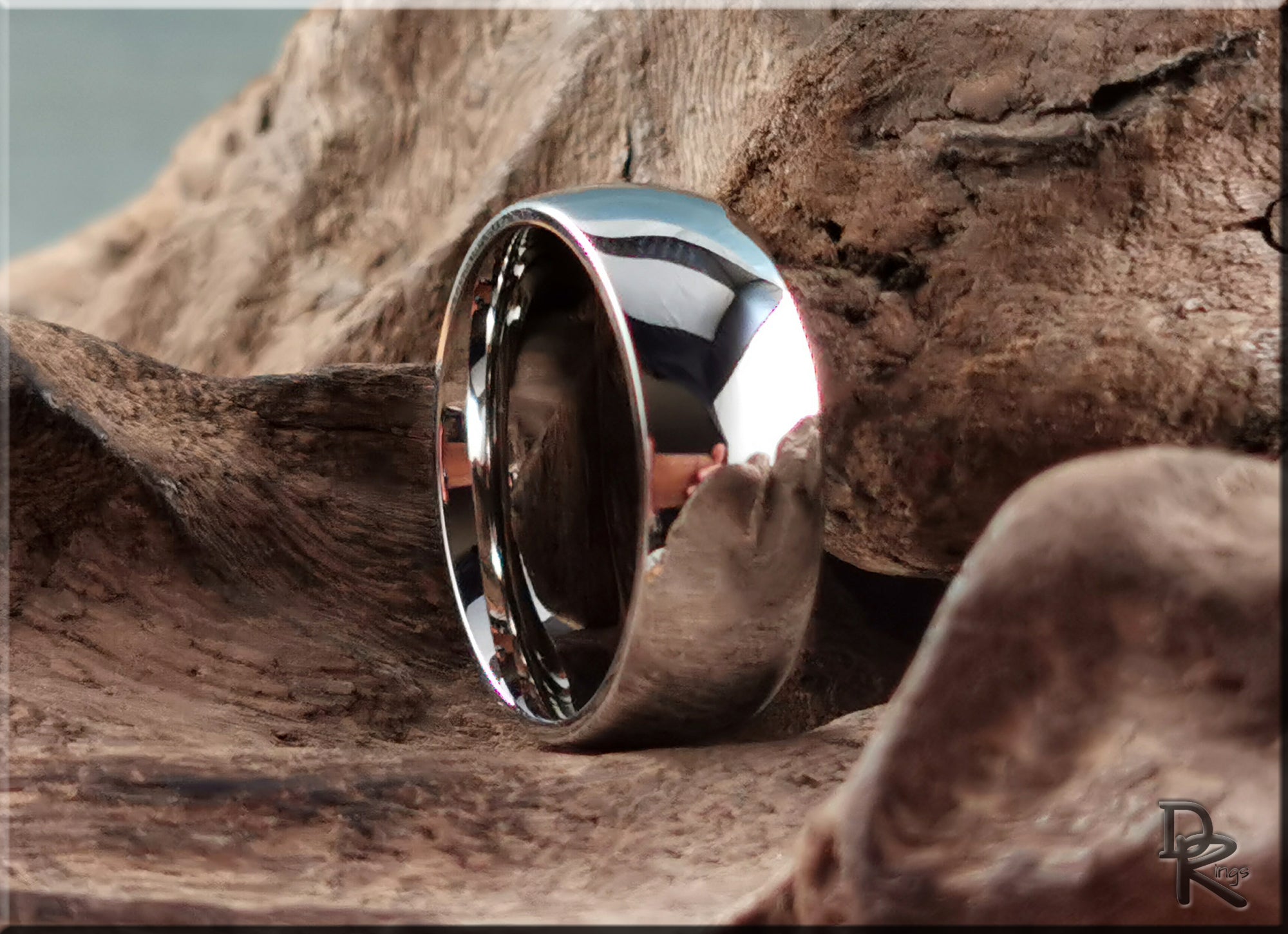 Shiny domed cobalt ring from DR Rings resting on textured wood background