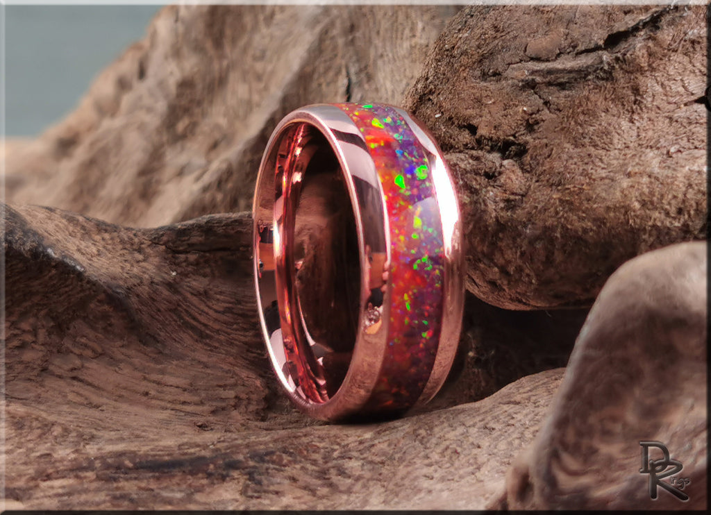 Brushed tellurium copper ring with opal inlay showing vibrant colors set against rustic wood background