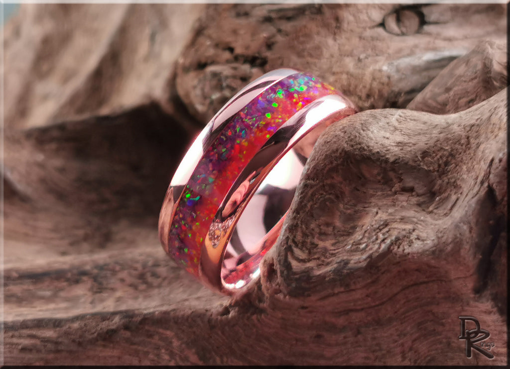 Brushed tellurium copper ring with opal featuring vibrant red and green opal inlay on rustic wood