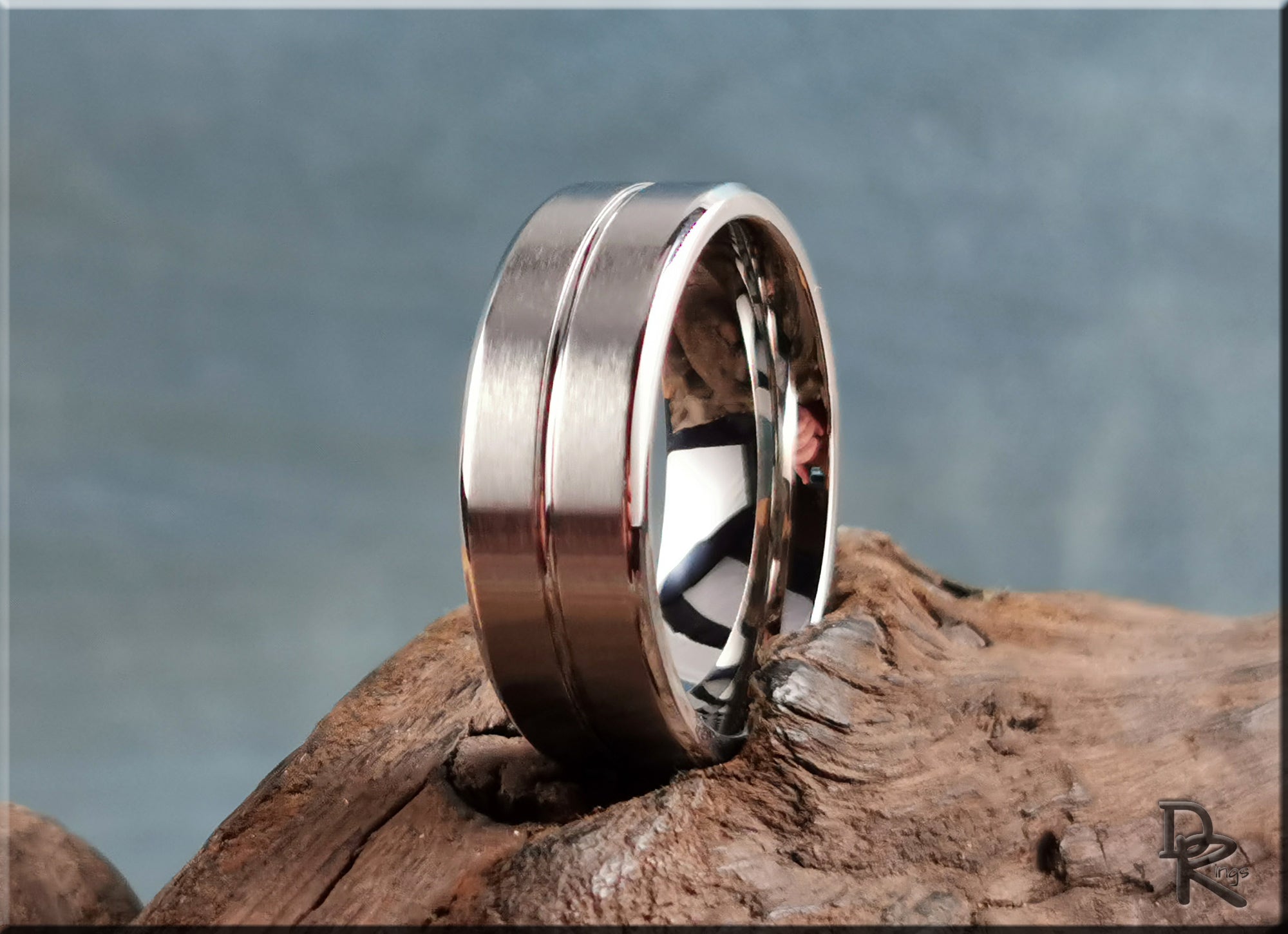 DR Rings sleek polished cobalt ring with dual groove design resting on rustic wooden surface