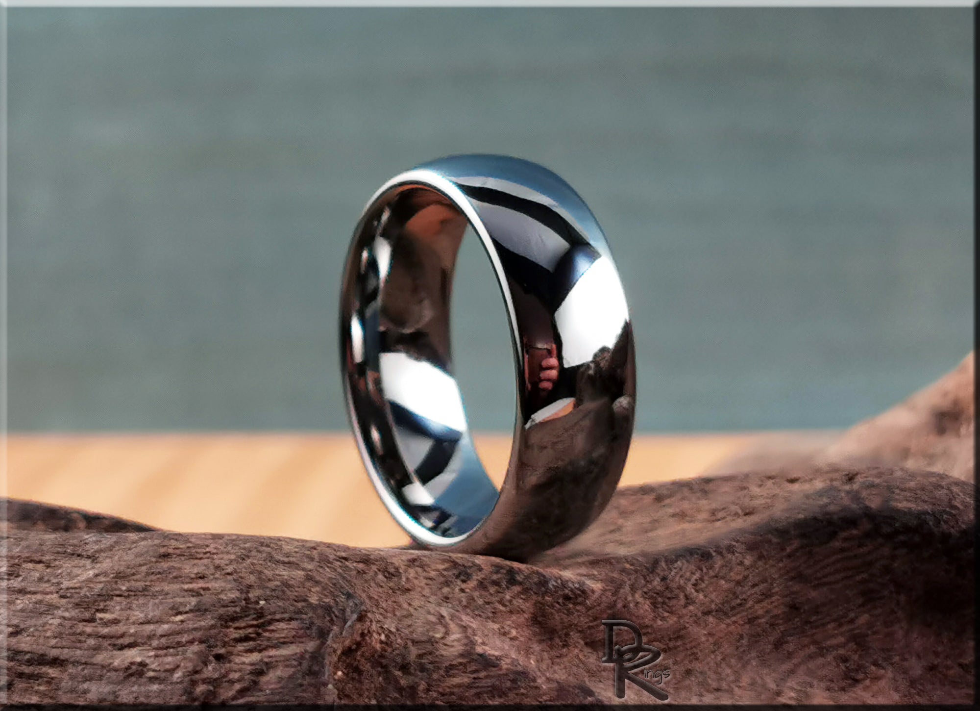 DR Rings domed tungsten ring with polished finish displayed on textured wood surface