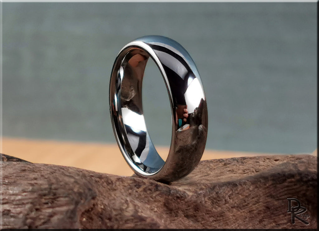 DR Rings polished domed tungsten ring with a smooth reflective surface on a natural wood background