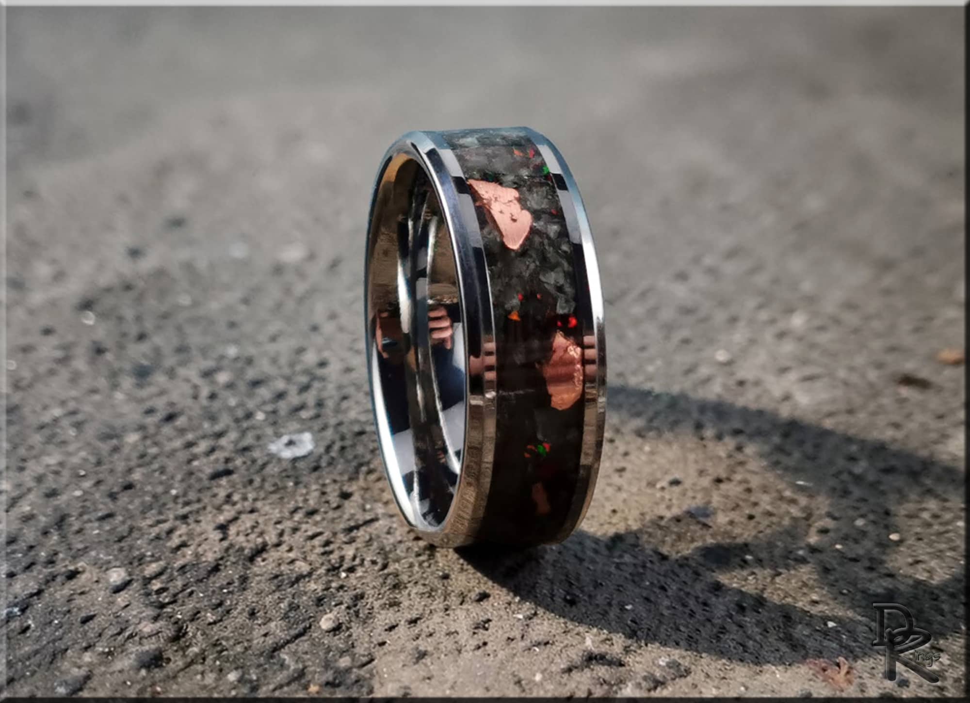 DR Rings tungsten ring carbide with yooperlite featuring a polished black and metallic design on textured surface