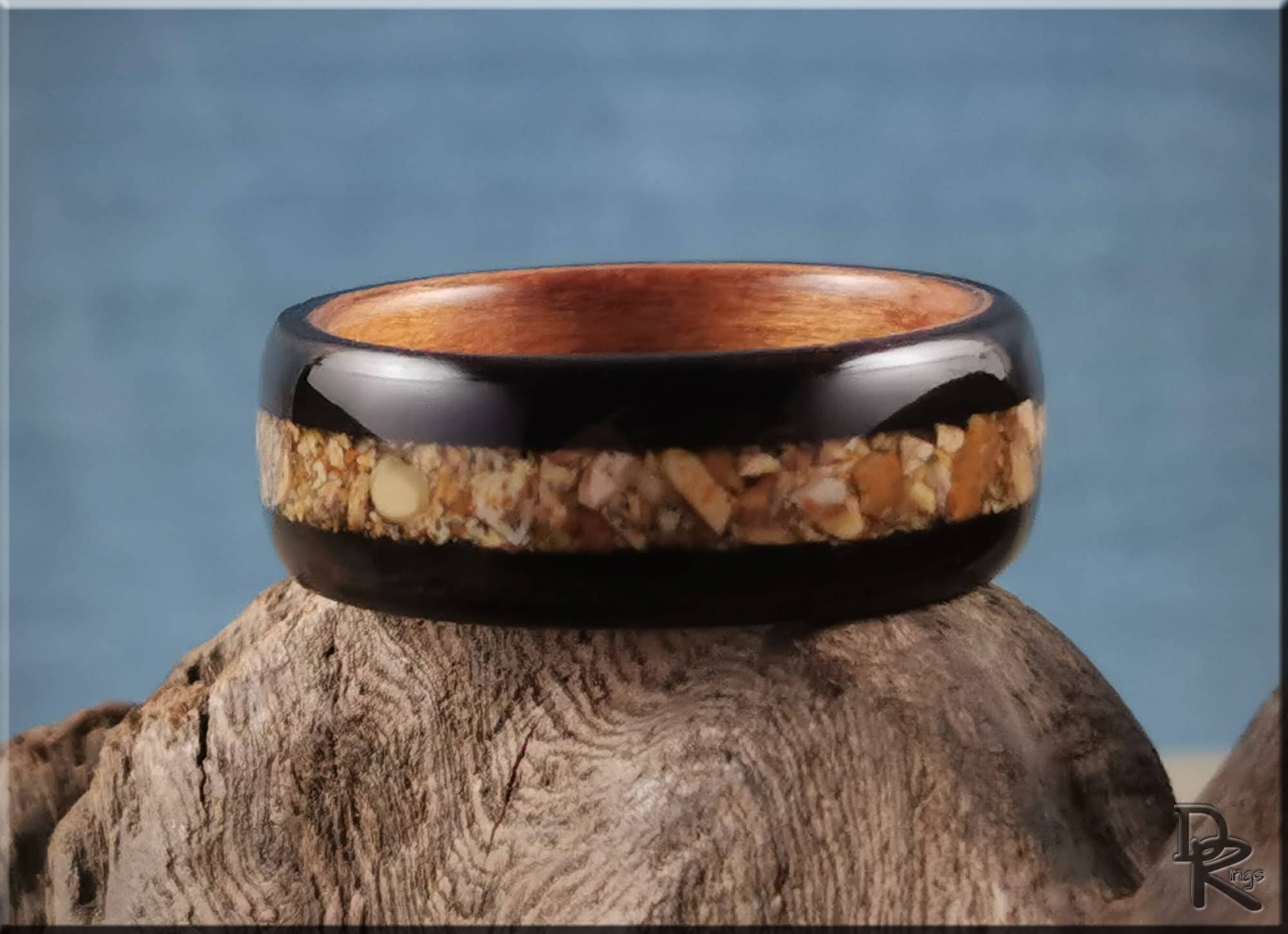 DR Rings wooden ring with natural inlay resting on textured wood showing how to get rid of water ring on wood