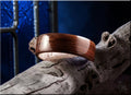 Bog oak wooden ring with polished finish displayed on rustic driftwood by DR Rings