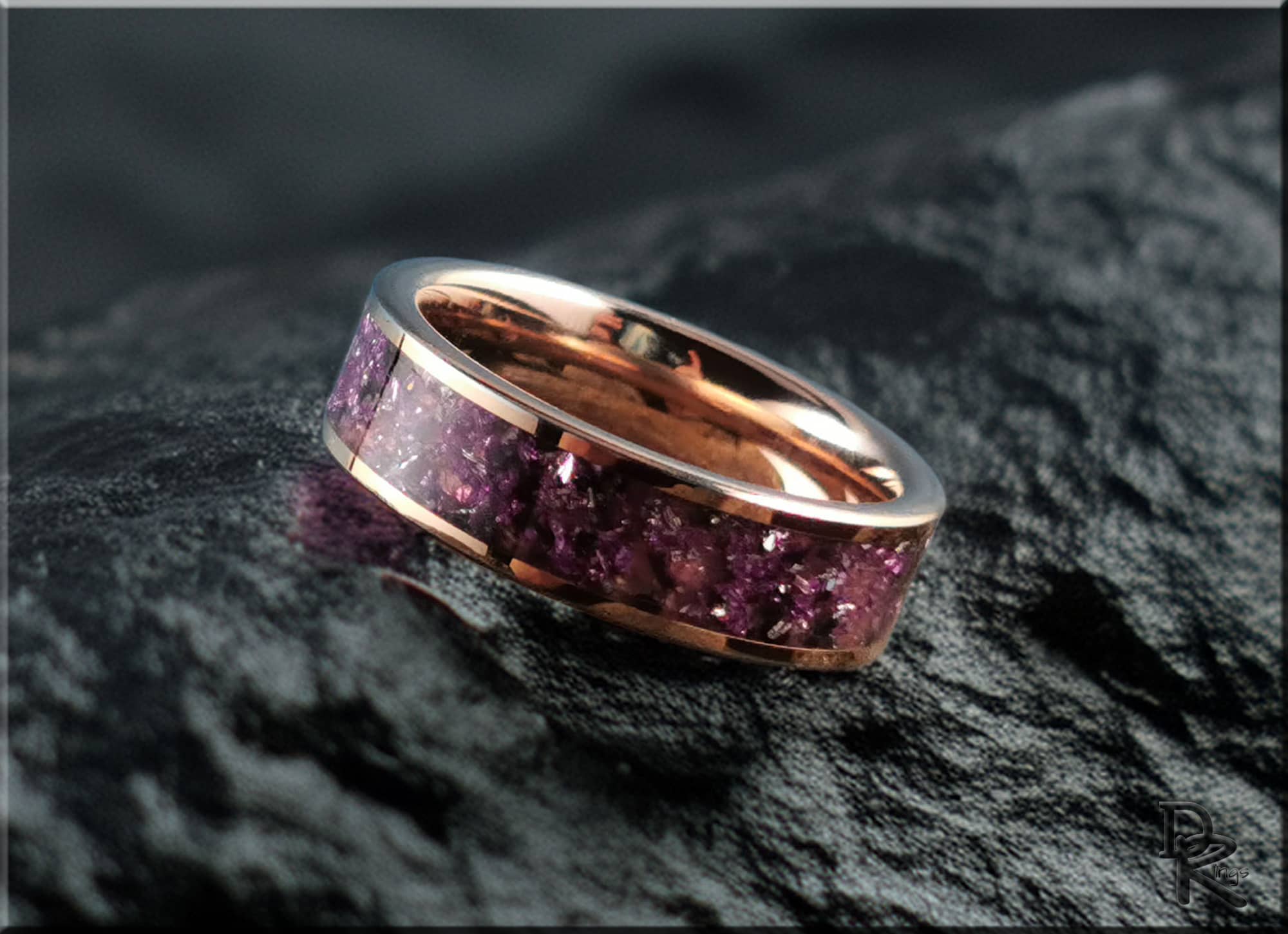 Rose tungsten ring with german glass featuring vibrant purple inlay on a reflective surface