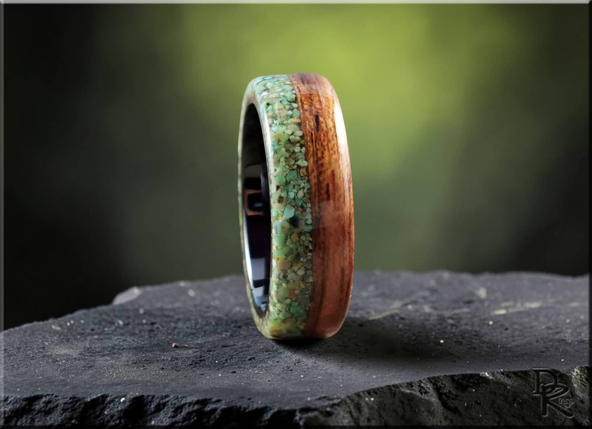 DR Rings turquoise inlay rings with wood and stone design on a dark stone surface