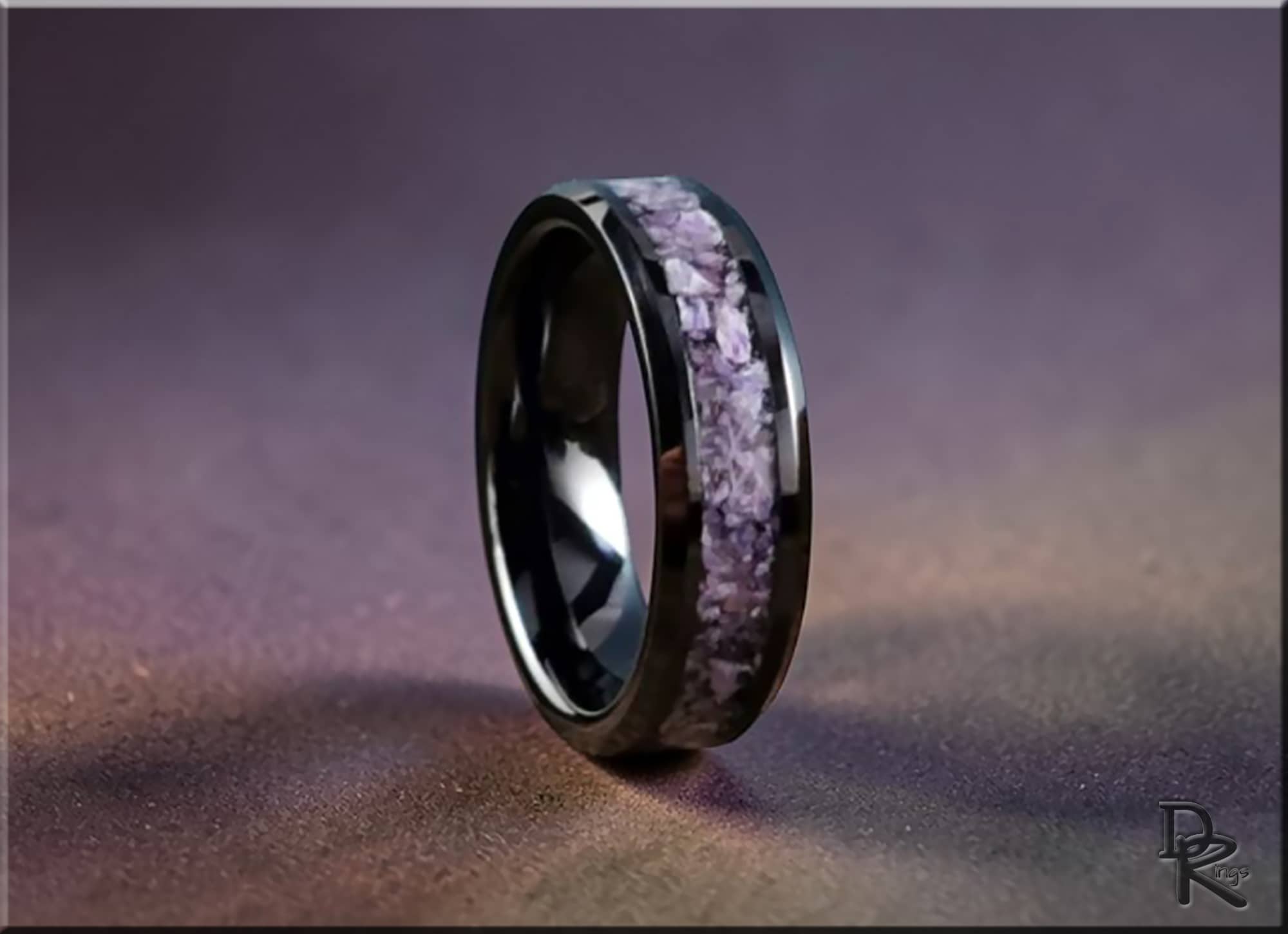 Black ceramic ring with charoite inlay by DR Rings on purple textured background