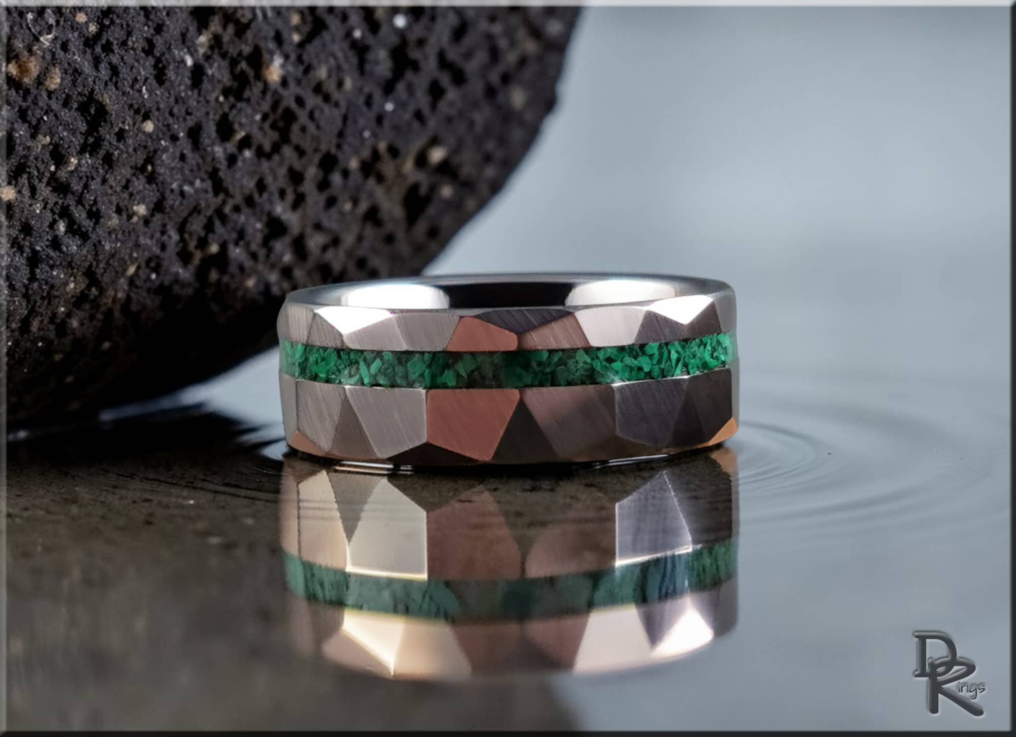 Hammered tungsten ring with malachite green inlay by DR Rings on reflective surface