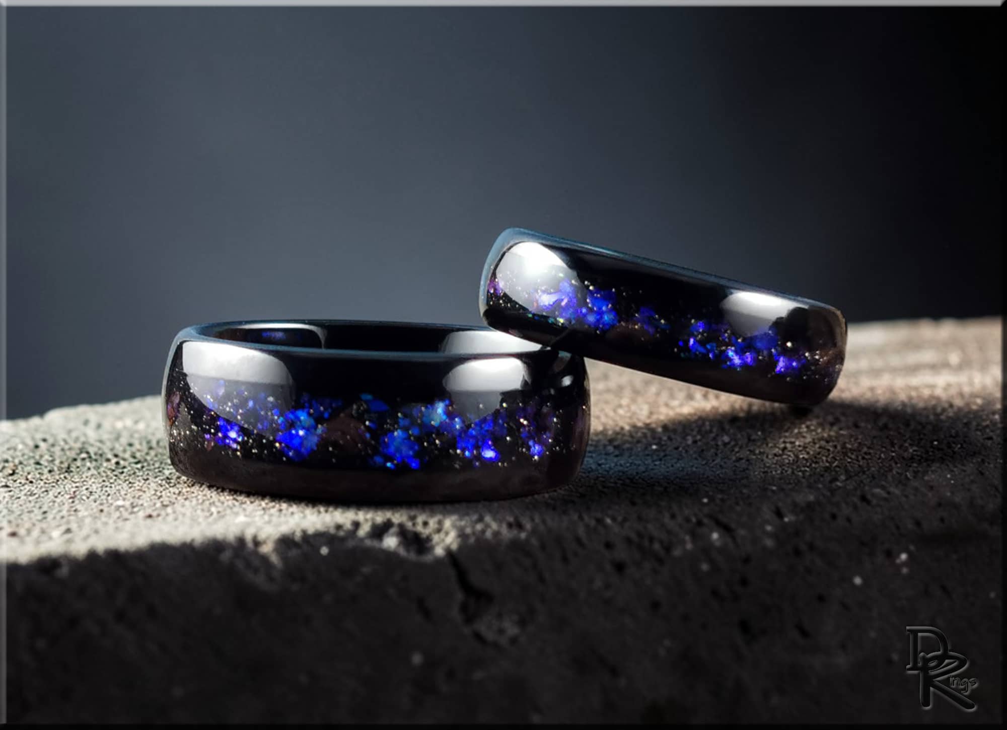 DR Rings polished black tungsten as a ring with blue galaxy pattern inlay on textured surface