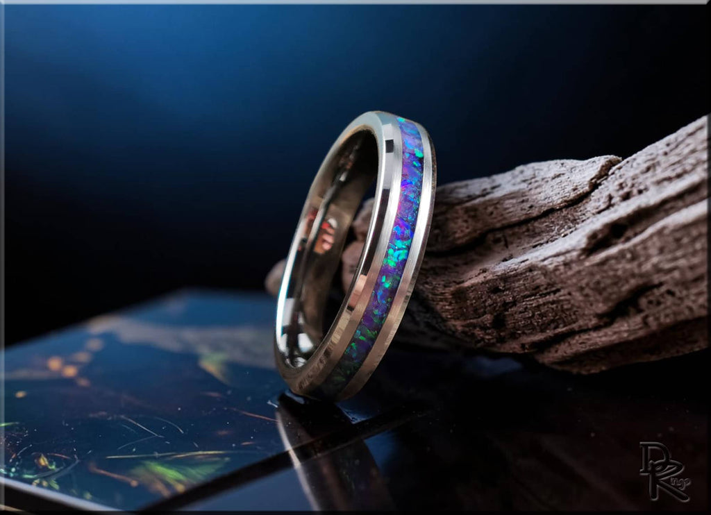 Tungsten carbide ring with opal inlay showcasing vibrant blue and purple hues on dark background