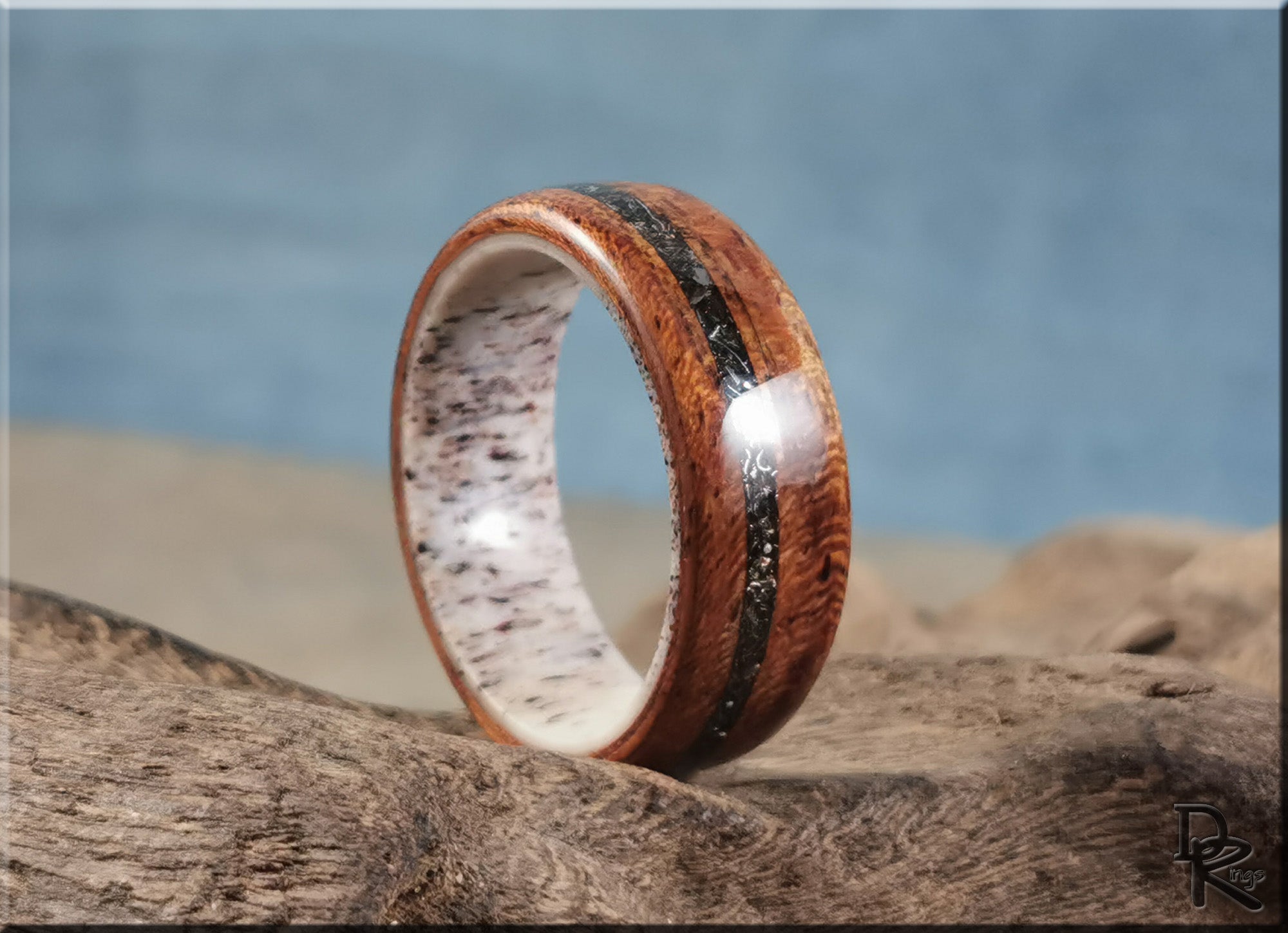 Wood ring with meteorite inlay on deer antler core by DR Rings displayed on rustic wood