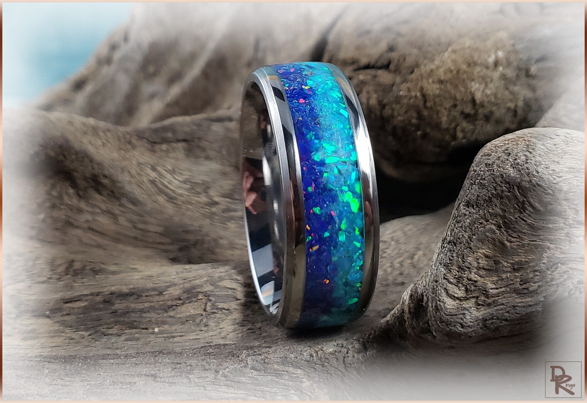 Titanium ring with opal featuring vibrant blue and green inlay on a polished band by DR Rings