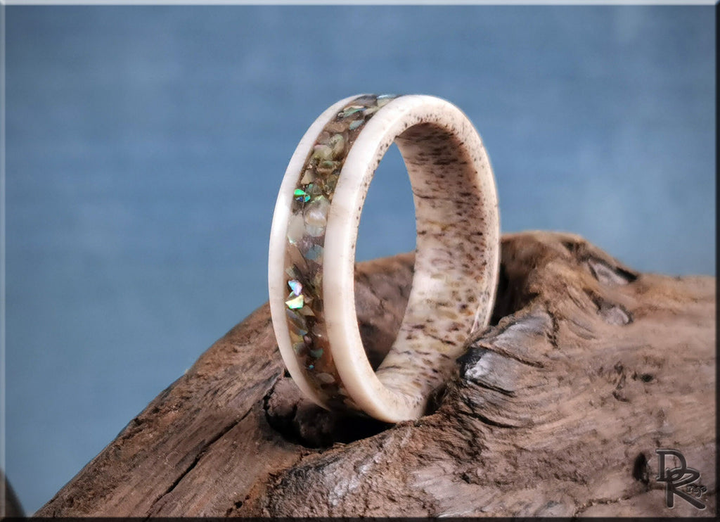 DR Rings antler ring with abalone inlay featuring natural texture on rustic wood