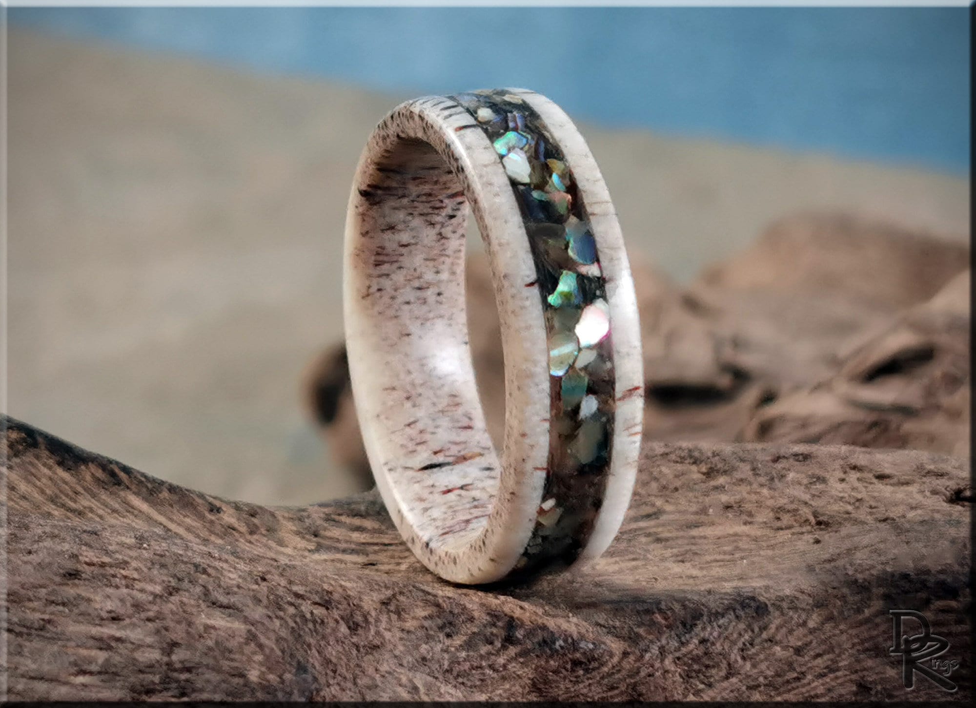 Antler ring with abalone inlay featuring natural wood texture and iridescent stones