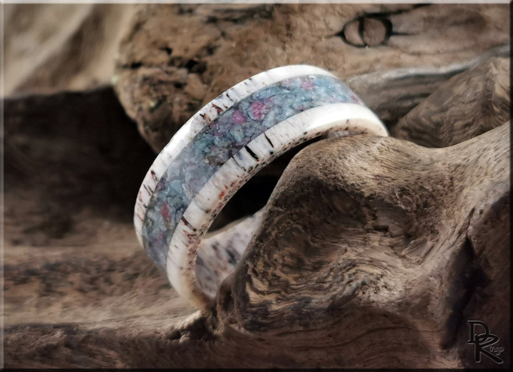 Antler ring with kyanite and ruby embedded in natural wood background by DR Rings