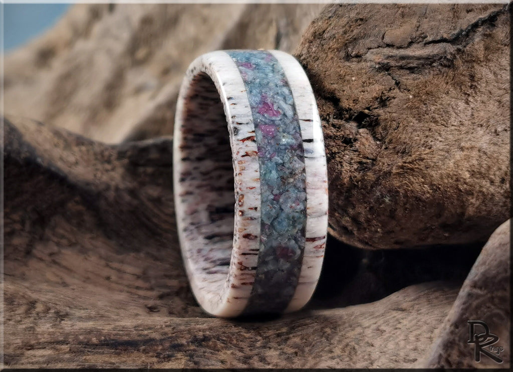Antler ring with kyanite and ruby inlay by DR Rings displayed on rustic wooden surface