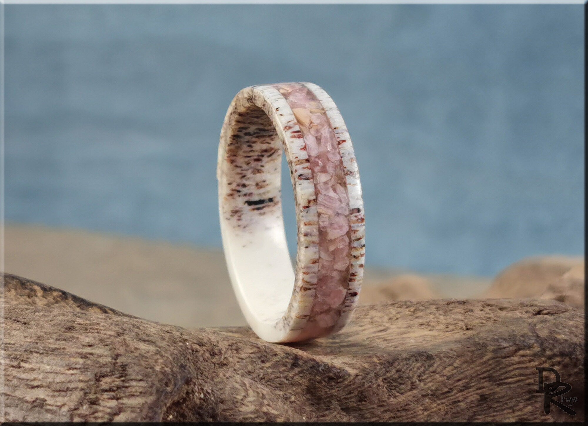 Antler Ring with stone inlay featuring pink stone and natural antler material on textured wood