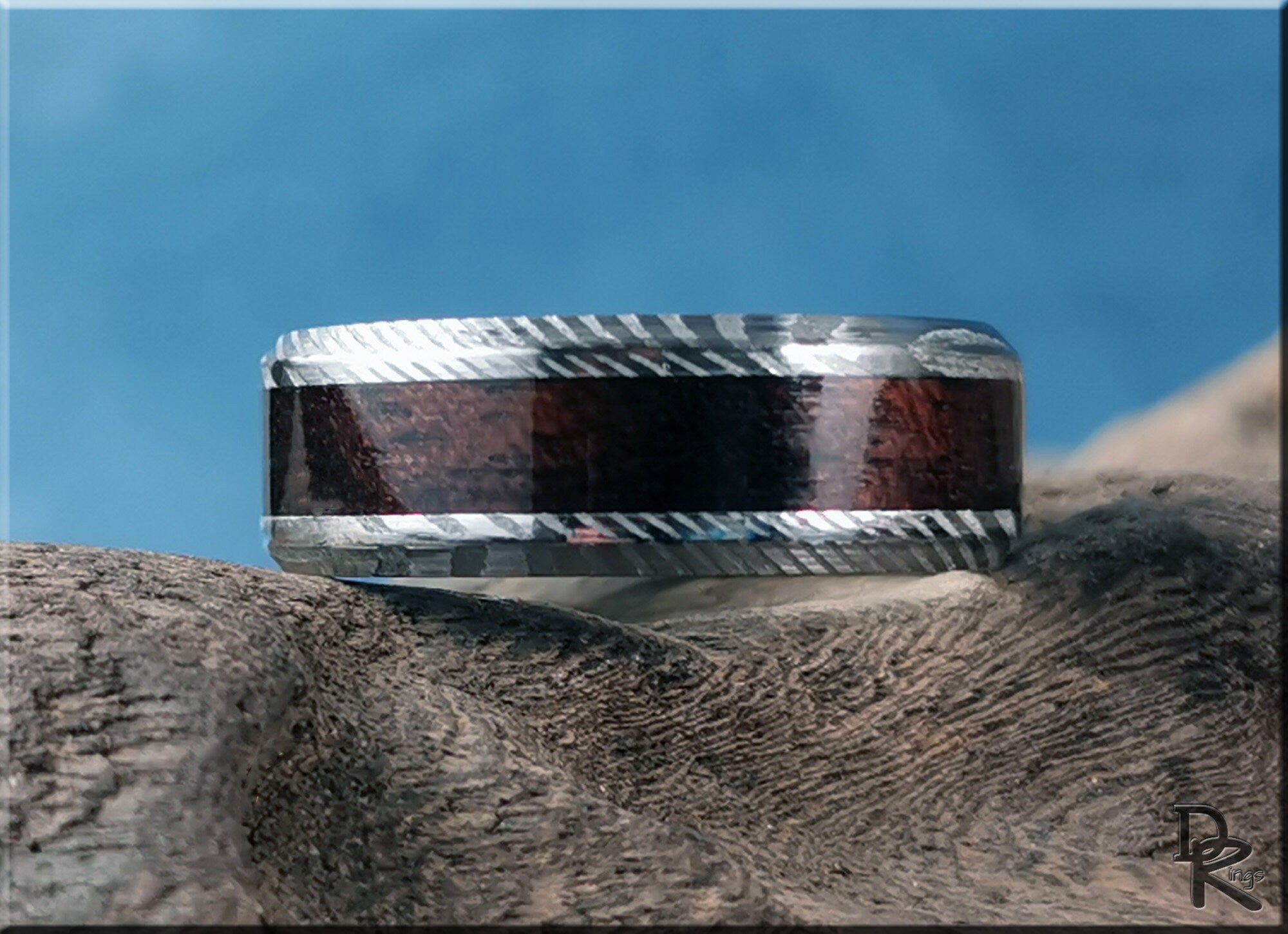Damascus steel ring with wood inlay featuring a textured silver pattern and rich dark wood strip