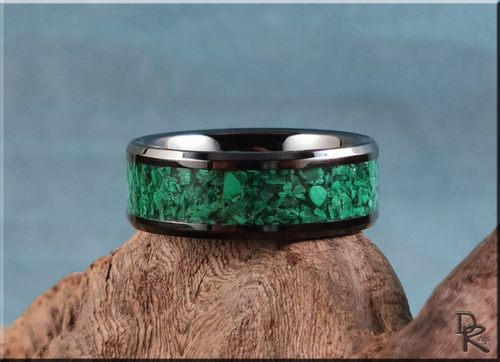 Black ceramic ring with vibrant green stone inlay by DR Rings displayed on wood