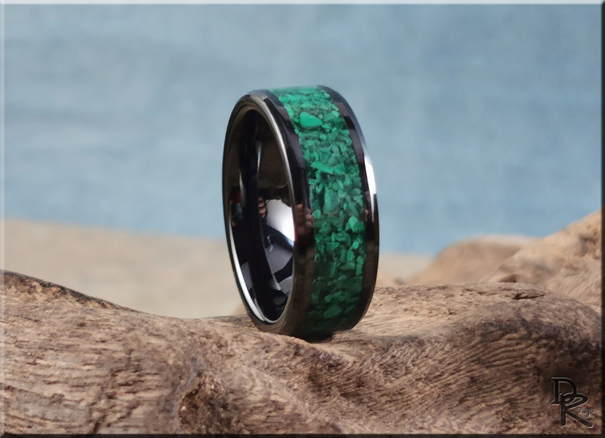 DR Rings black ceramic ring with green stone inlay on textured wood background