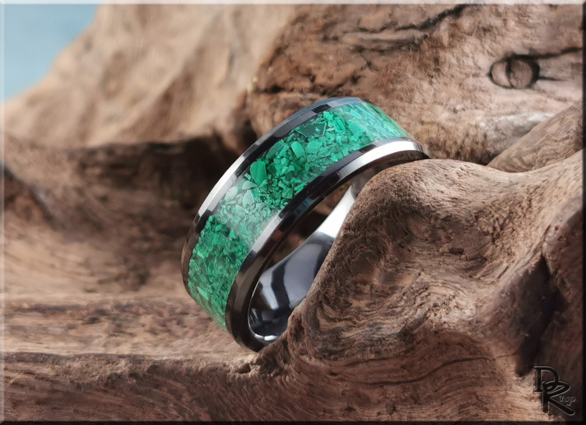 DR Rings black ceramic ring with vibrant green stone inlay displayed on natural wood background